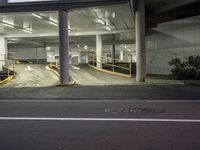 an empty parking garage with two signs on it's sides and a sidewalk area with steps next to it