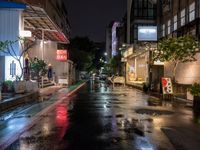 a wet city street is lit up at night as the rain starts to fall into the air