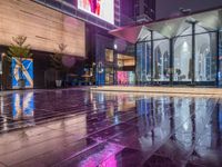 this is an image of a wet city streets at night in the rain - covered ground