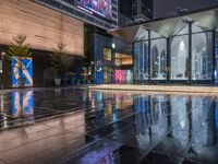 this is an image of a wet city streets at night in the rain - covered ground