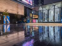 this is an image of a wet city streets at night in the rain - covered ground