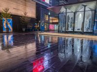 this is an image of a wet city streets at night in the rain - covered ground