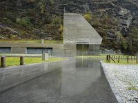 this is an image of a driveway near mountains and trees in the rain on a rainy day