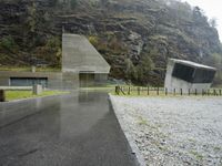 this is an image of a driveway near mountains and trees in the rain on a rainy day