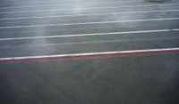 a parking lot in the middle of a wet parking lot with red and white painted lines