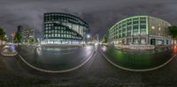 a big, wide angle shot of a busy street at night time the reflection of an office building