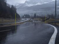 wet road with mountains in the distance and rain on the street and side in the foreground