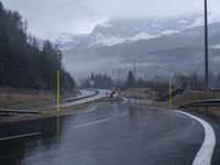 wet road with mountains in the distance and rain on the street and side in the foreground