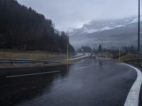 wet road with mountains in the distance and rain on the street and side in the foreground