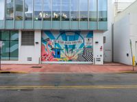 a stop sign is in front of an office building that has a large colorful mural on it