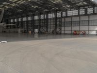 a white commercial aircraft is parked outside a hangar and a white car is parked inside a hangar