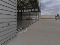 a white commercial aircraft is parked outside a hangar and a white car is parked inside a hangar