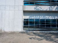 a white brick walkway in front of a building with a glass door on one side