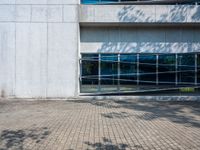 a white brick walkway in front of a building with a glass door on one side