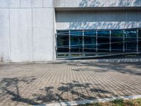 a white brick walkway in front of a building with a glass door on one side