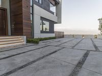 the exterior and landscape of a modern house in los angeles, california with stone and wood