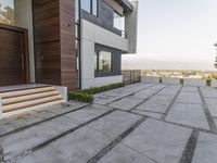 the exterior and landscape of a modern house in los angeles, california with stone and wood