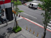 a white delivery truck driving through a city street with red and white lines on the streets