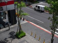 a white delivery truck driving through a city street with red and white lines on the streets