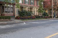 a white double decker parked next to an empty street side walk with many plant pots in it