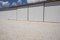 there is a white fence in front of a garage door with red trim and large windows