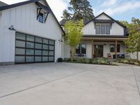 a white house with garage doors is seen from the outside out front on an open driveway