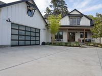 a white house with garage doors is seen from the outside out front on an open driveway