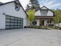 a white house with garage doors is seen from the outside out front on an open driveway