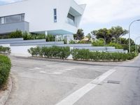 a white modern house that has been built into the side of the road in spain