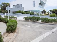 a white modern house that has been built into the side of the road in spain