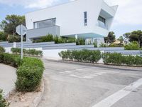 a white modern house that has been built into the side of the road in spain