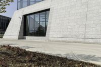 a white stone building with windows and a red fire hydrant on the sidewalk by some grass