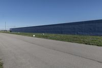 a row of white toilet tissue left on the side of the road near the wall