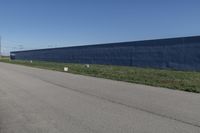 a row of white toilet tissue left on the side of the road near the wall