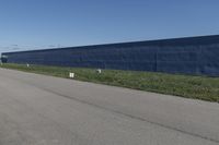 a row of white toilet tissue left on the side of the road near the wall