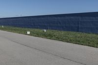 a row of white toilet tissue left on the side of the road near the wall