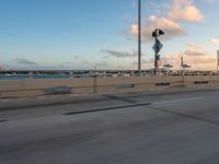 a very wide bridge with a view of the ocean in the background in the foreground