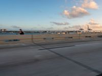 a very wide bridge with a view of the ocean in the background in the foreground