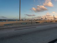 a very wide bridge with a view of the ocean in the background in the foreground