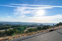 there are many clouds above the horizon and mountains in this picture of a wide open road