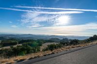 there are many clouds above the horizon and mountains in this picture of a wide open road