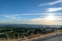 there are many clouds above the horizon and mountains in this picture of a wide open road