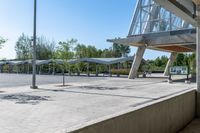 there is a very wide parking lot outside a building with clear glass doors and glass walls