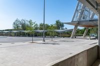 there is a very wide parking lot outside a building with clear glass doors and glass walls