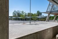 there is a very wide parking lot outside a building with clear glass doors and glass walls