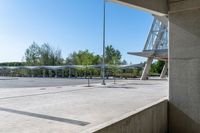 there is a very wide parking lot outside a building with clear glass doors and glass walls