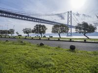 a wide road in front of a bridge and some grass on the side of it