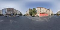 a view of a very wide street with some buildings and some trees in it from the fisheye lens