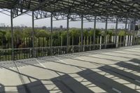 a photo of a very wide outdoor stage overlooking the skyline while someone is using a cell phone