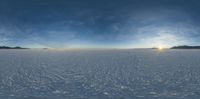 a wide view of some very thin snow and the sun is shining through clouds and shadows